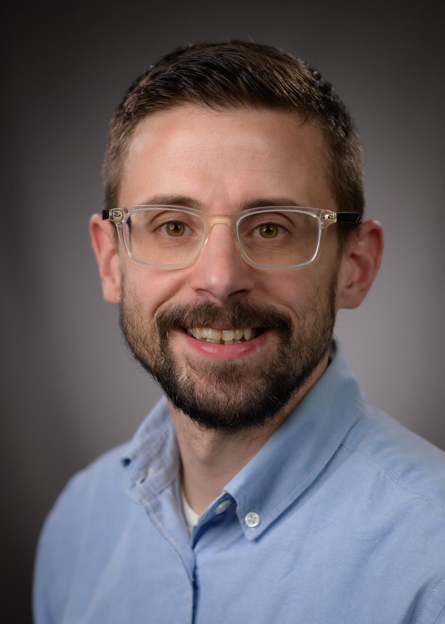 man, glasses, beard, smiling, blue shirt